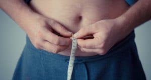 homme mesurant la graisse du ventre